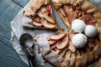 Delicious apple galette with ice cream and pecans on wooden table, flat lay