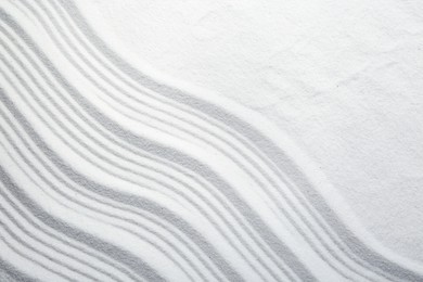 Photo of Zen rock garden. Wave pattern on white sand, top view