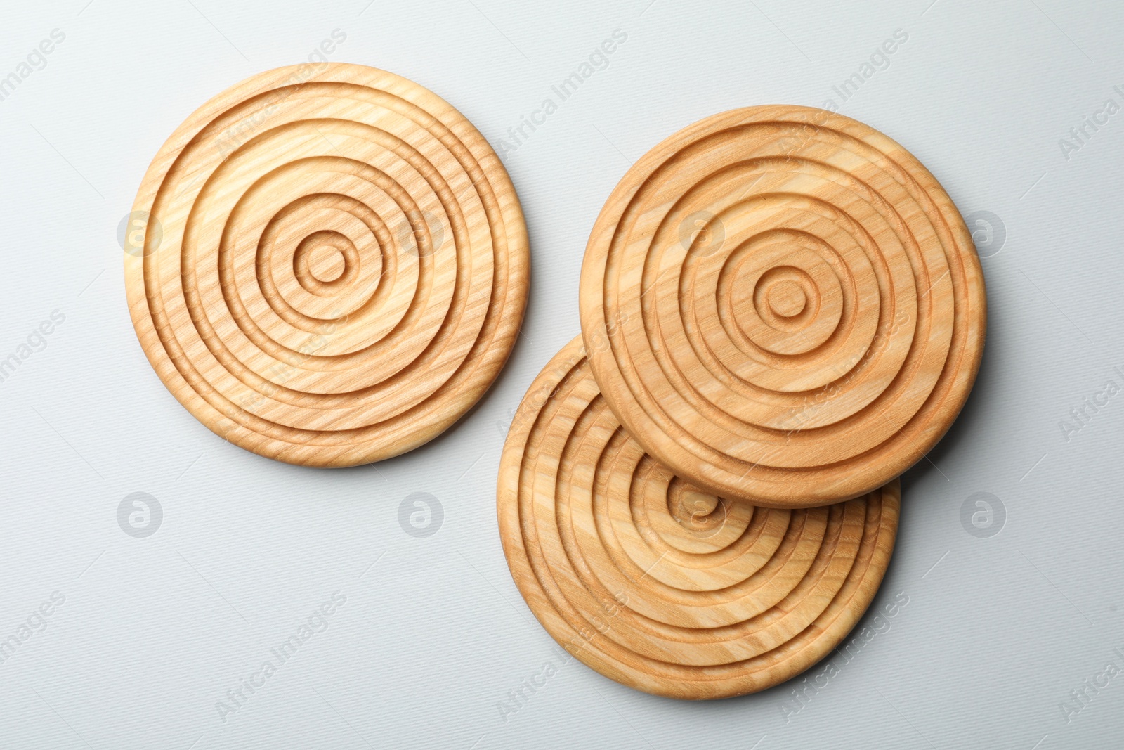 Photo of Stylish wooden cup coasters on light background, flat lay