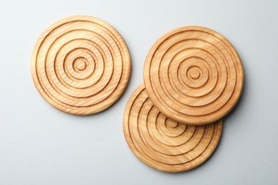 Photo of Stylish wooden cup coasters on light background, flat lay