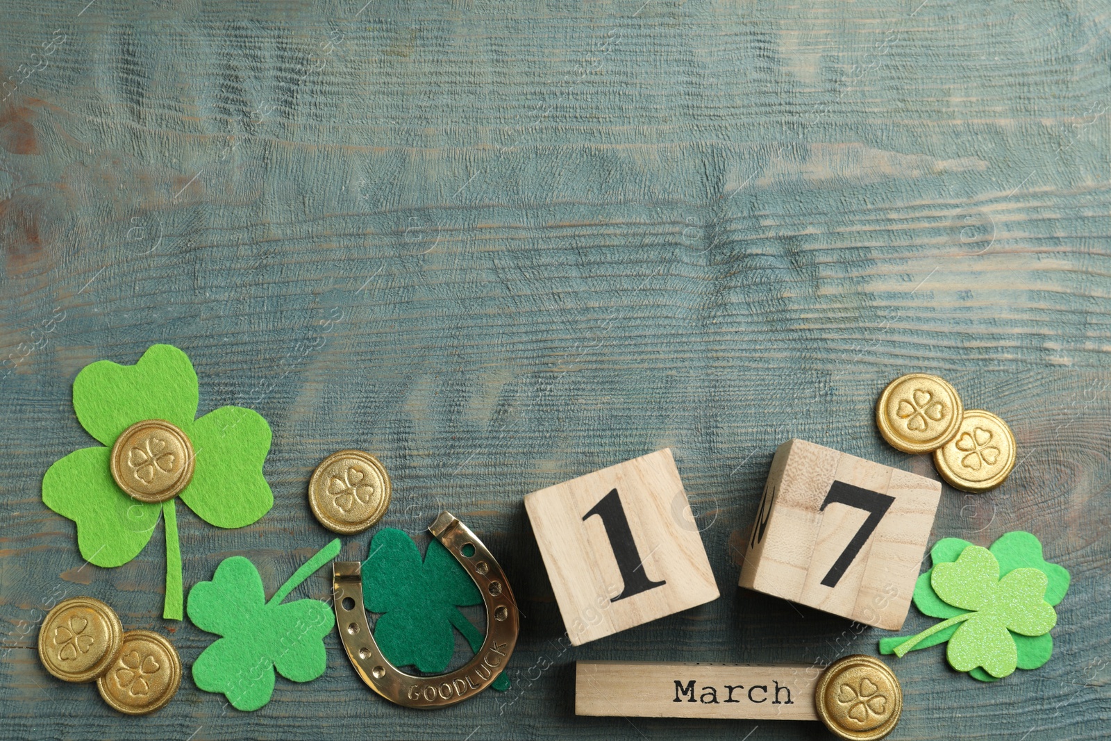 Photo of Flat lay composition with clover leaves and block calendar on light blue wooden background, space for text. St. Patrick's day