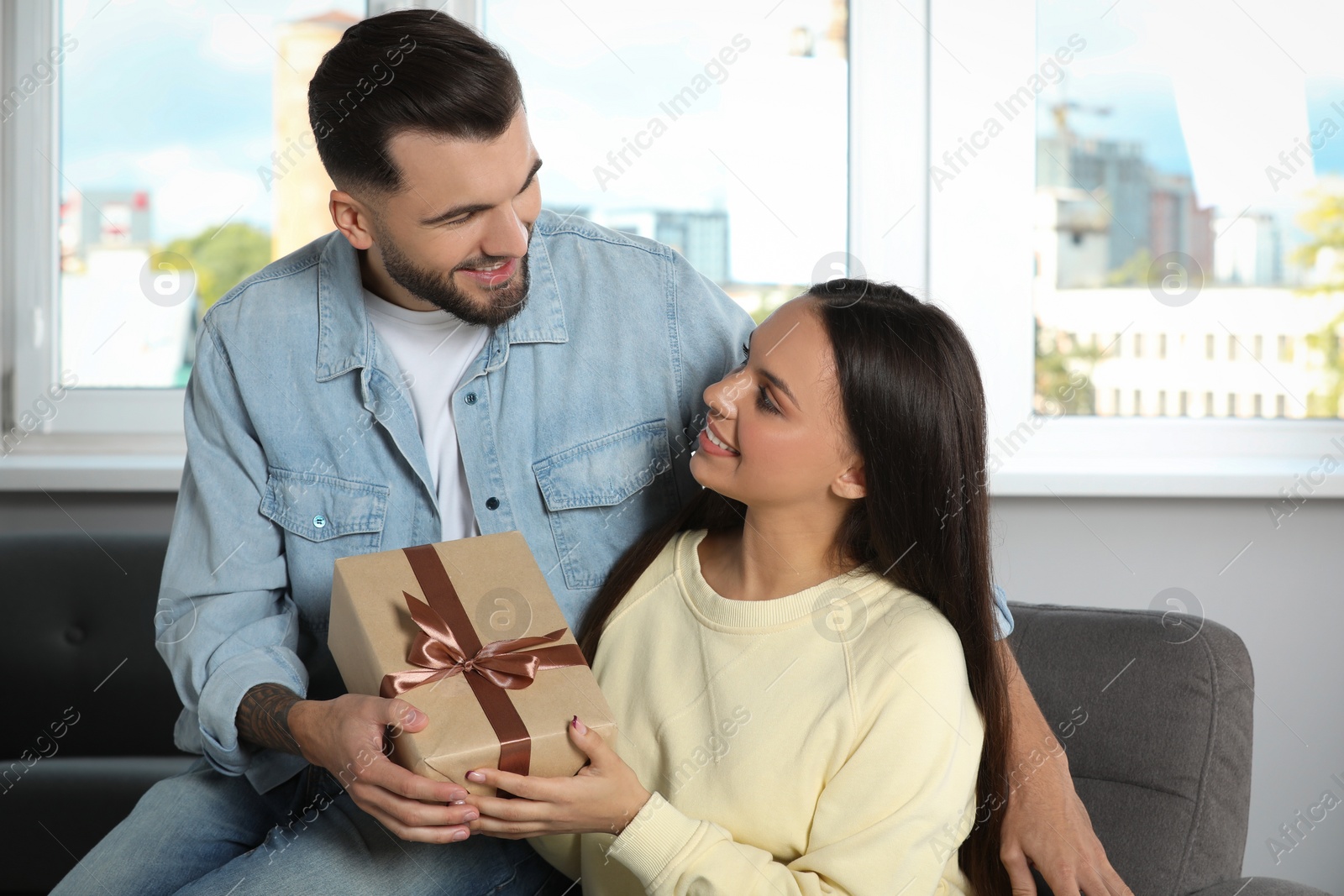 Photo of Lovely couple with beautiful gift at home