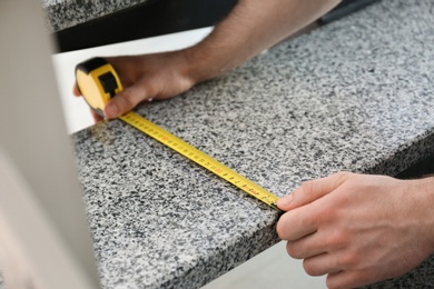Photo of Man measuring stone step, closeup. Construction tool