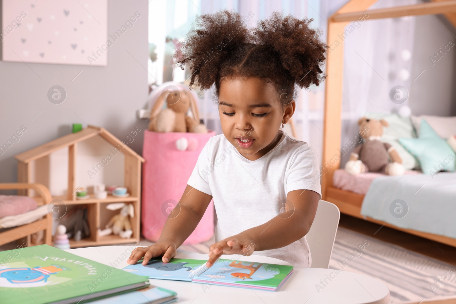 Photo of African American girl reading book at home