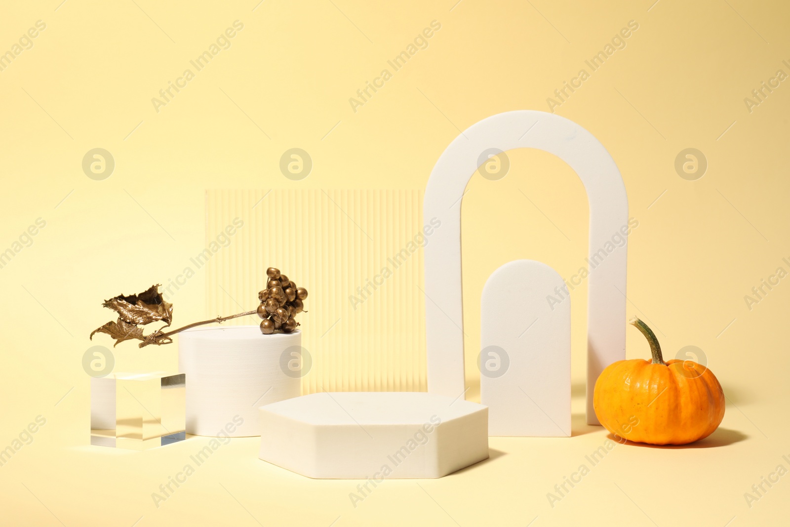 Photo of Autumn presentation for product. Geometric figures and decorative elements on light yellow background