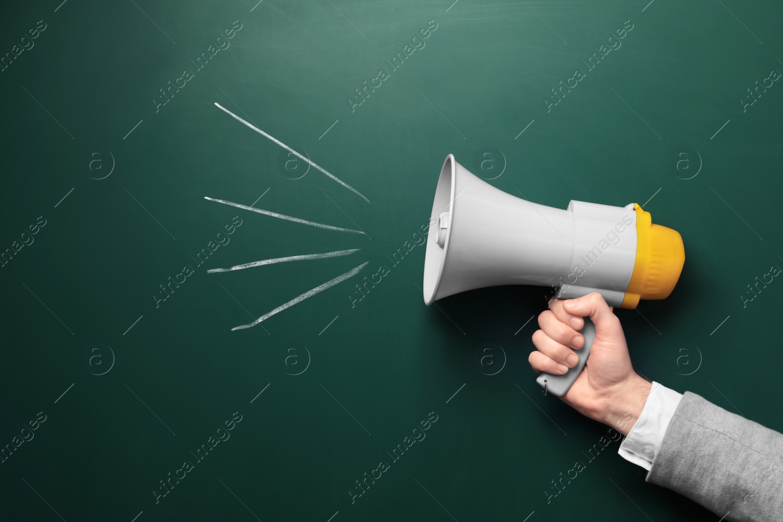 Photo of Man holding megaphone near chalkboard