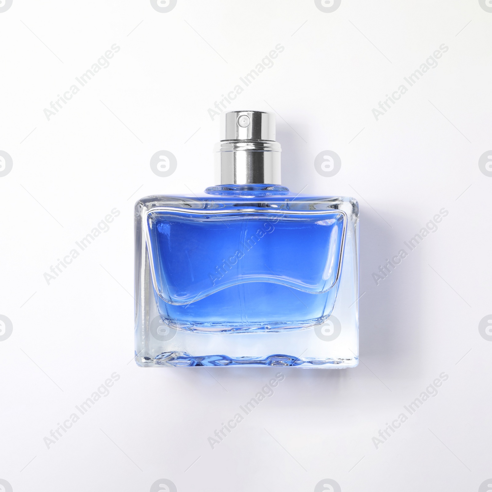 Photo of Blue men's perfume in bottle on white background, top view