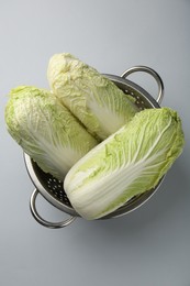 Fresh Chinese cabbages in colander on light background, top view