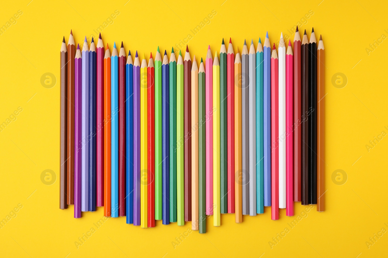 Photo of Colorful wooden pencils on yellow background, flat lay