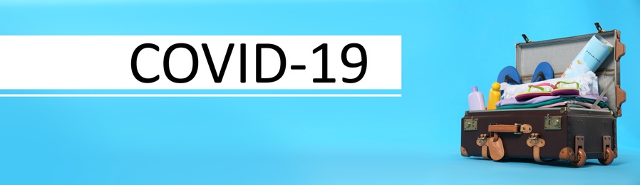 Image of Coronavirus pandemic, lockdown measures. Packed travel suitcase and text COVID-19 on blue background, banner design