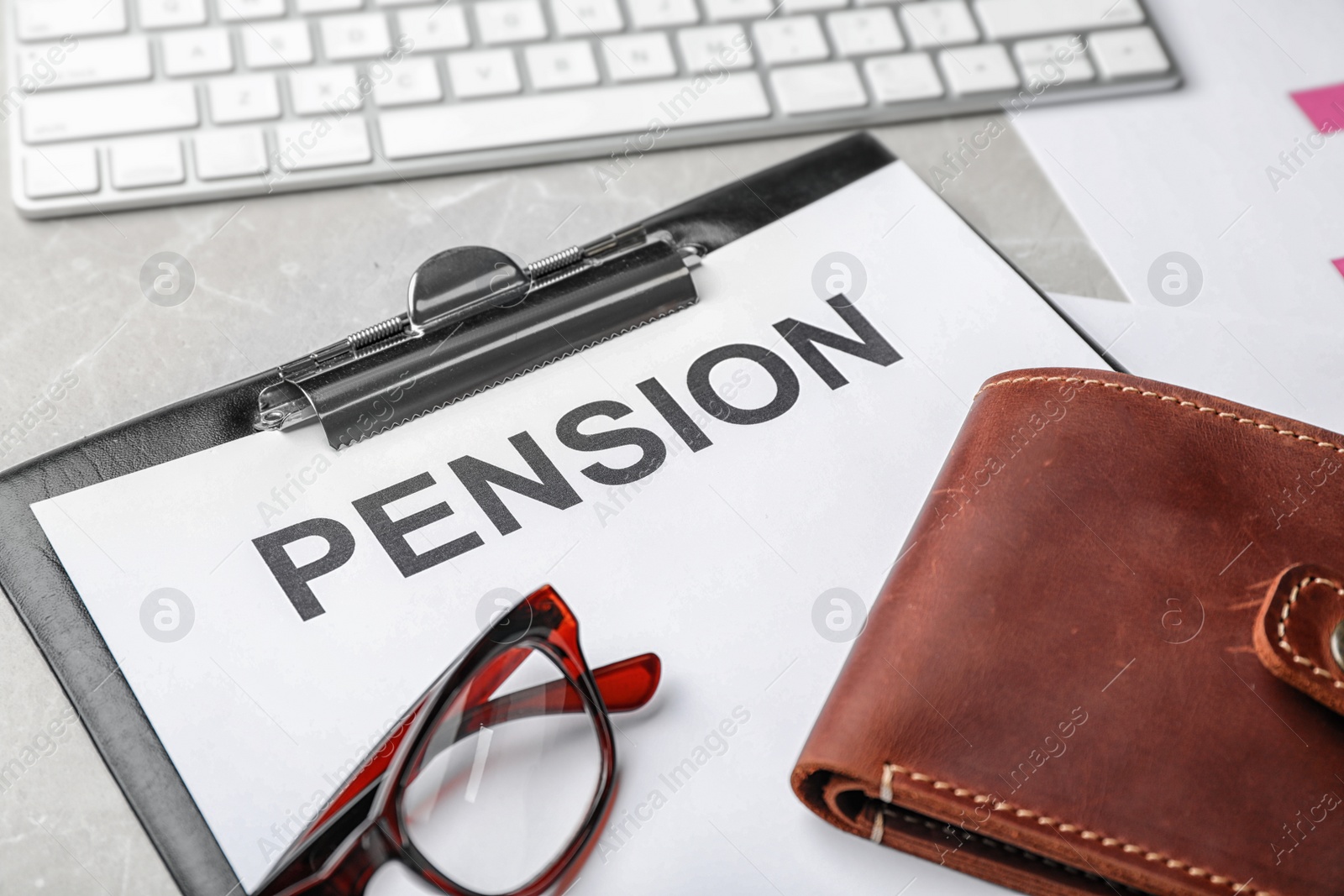 Photo of Glasses, wallet and paper with word PENSION on table