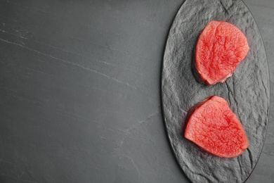 Photo of Fresh raw beef cut on black table, top view. Space for text