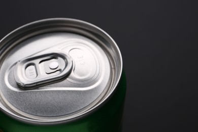 Photo of Energy drink in can on black background, closeup. Space for text