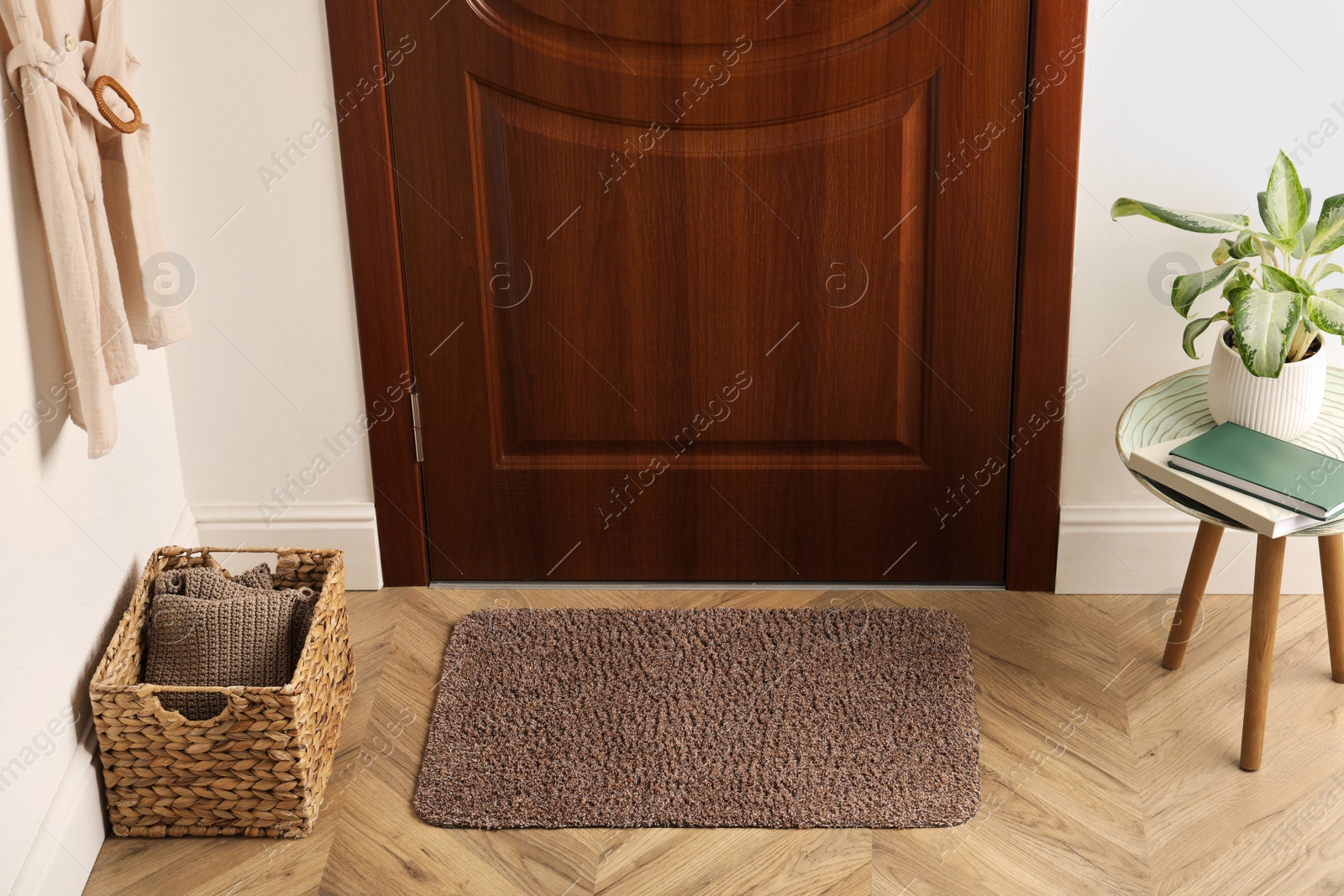 Photo of Clean door mat on wooden floor in hall