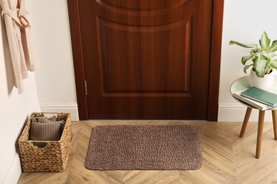 Clean door mat on wooden floor in hall
