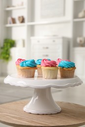 Delicious cupcakes with bright cream on wooden table indoors