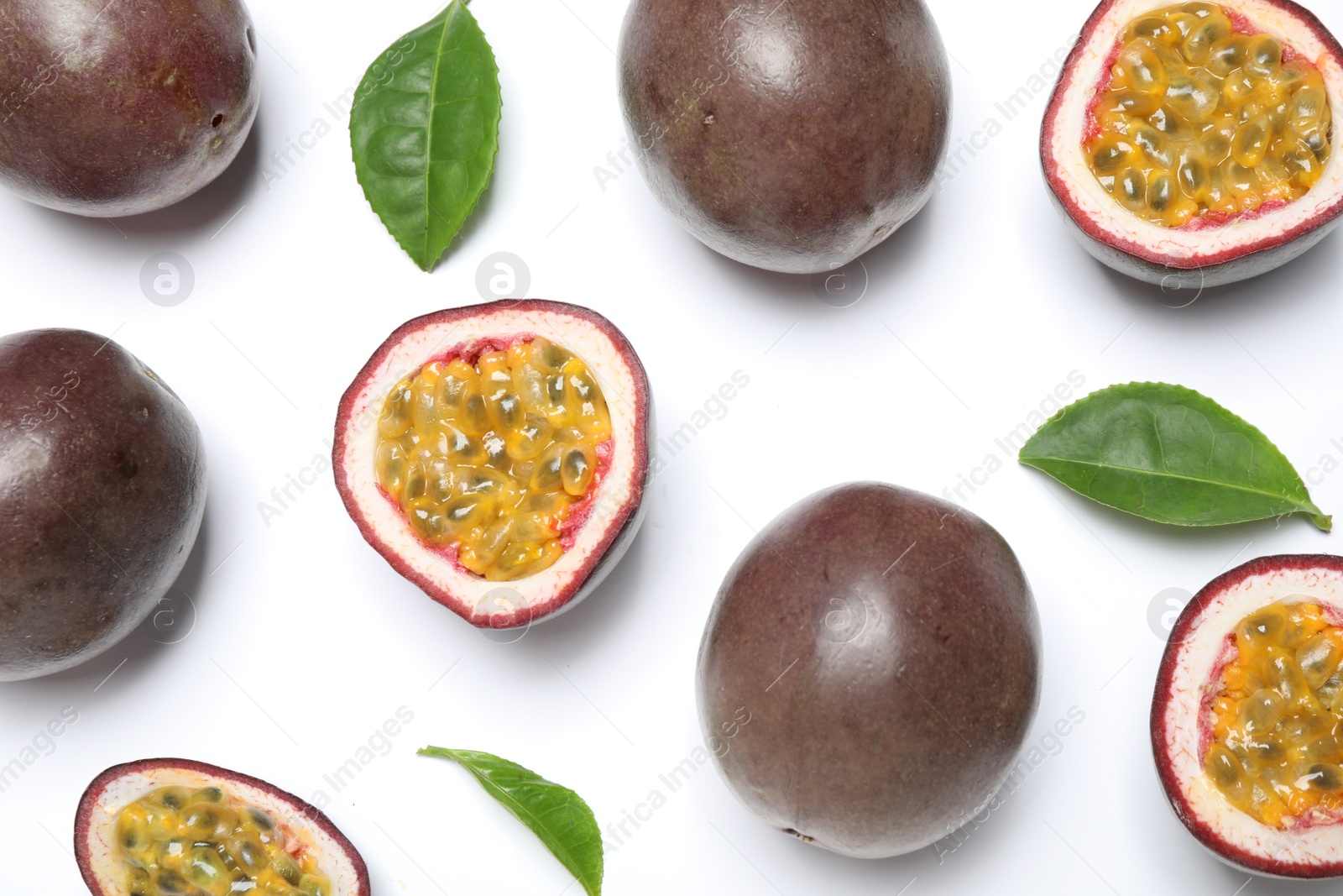 Photo of Fresh ripe passion fruits (maracuyas) with leaves on white background, flat lay