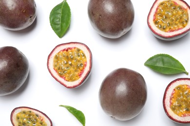 Fresh ripe passion fruits (maracuyas) with leaves on white background, flat lay