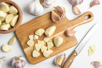 Photo of Fresh organic garlic on white wooden table, flat lay