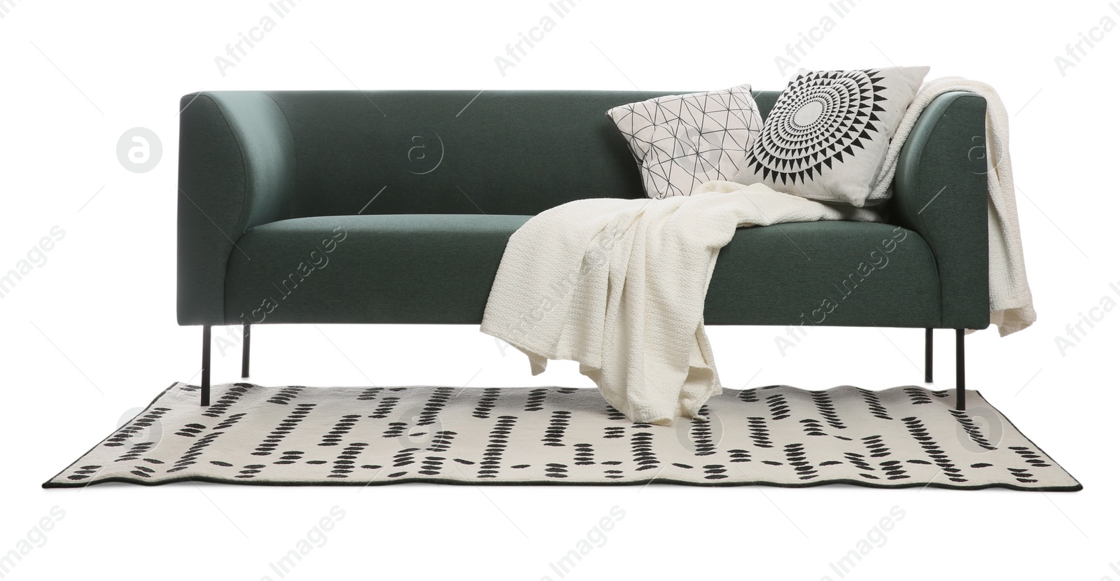 Photo of Comfortable green sofa with cushions, blanket and carpet on white background. Furniture for living room interior