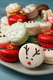 Photo of Beautifully decorated Christmas macarons on light blue table, closeup