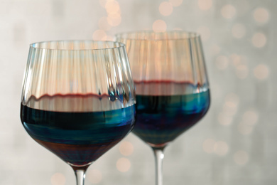 Photo of Glasses of red wine on light background, closeup