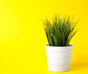 Photo of Beautiful artificial plant in flower pot on yellow background, space for text