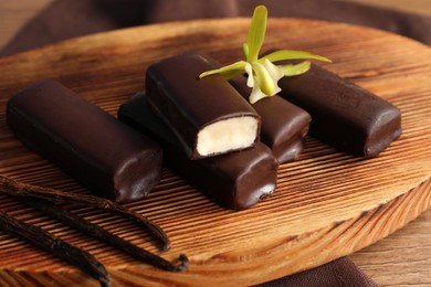 Photo of Glazed vanilla curd cheese bars served on wooden table, closeup