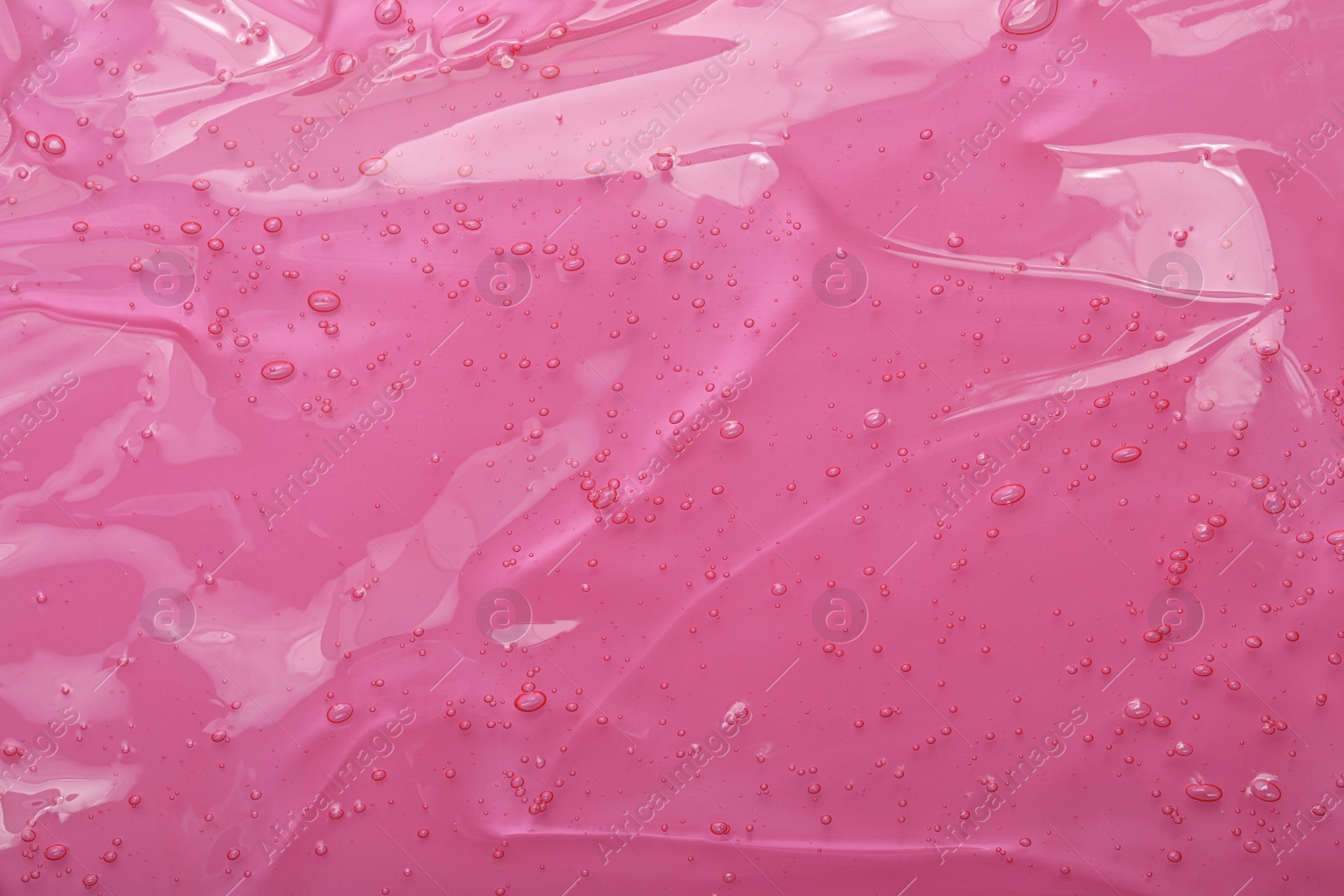 Photo of Pure transparent cosmetic gel on pink background, closeup