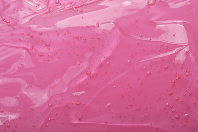 Pure transparent cosmetic gel on pink background, closeup