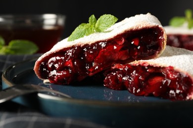 Photo of Delicious strudel with cherries, powdered sugar and mint on plate, closeup