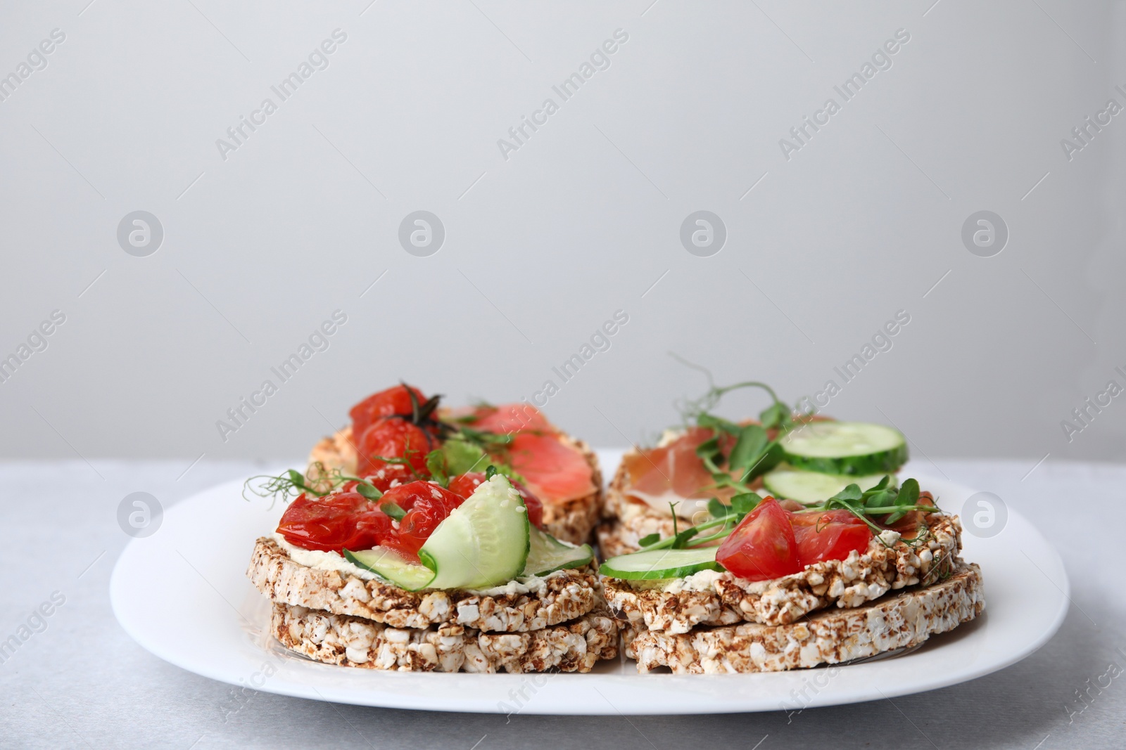 Photo of Crunchy buckwheat cakes with different ingredients on white table