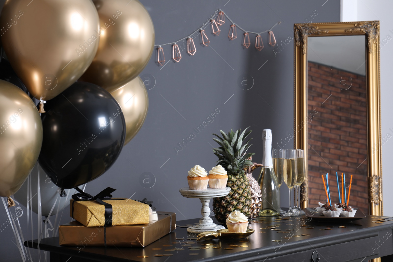 Photo of Party treats and items on table in room decorated with balloons