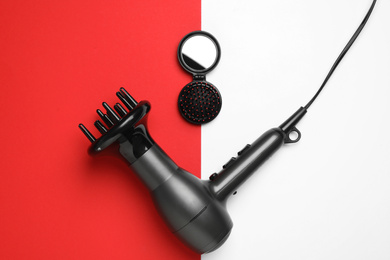 Photo of Hair dryer and brush on color background, flat lay. Professional hairdresser tool