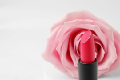 Beautiful pink lipstick and rose on white background, closeup. Space for text