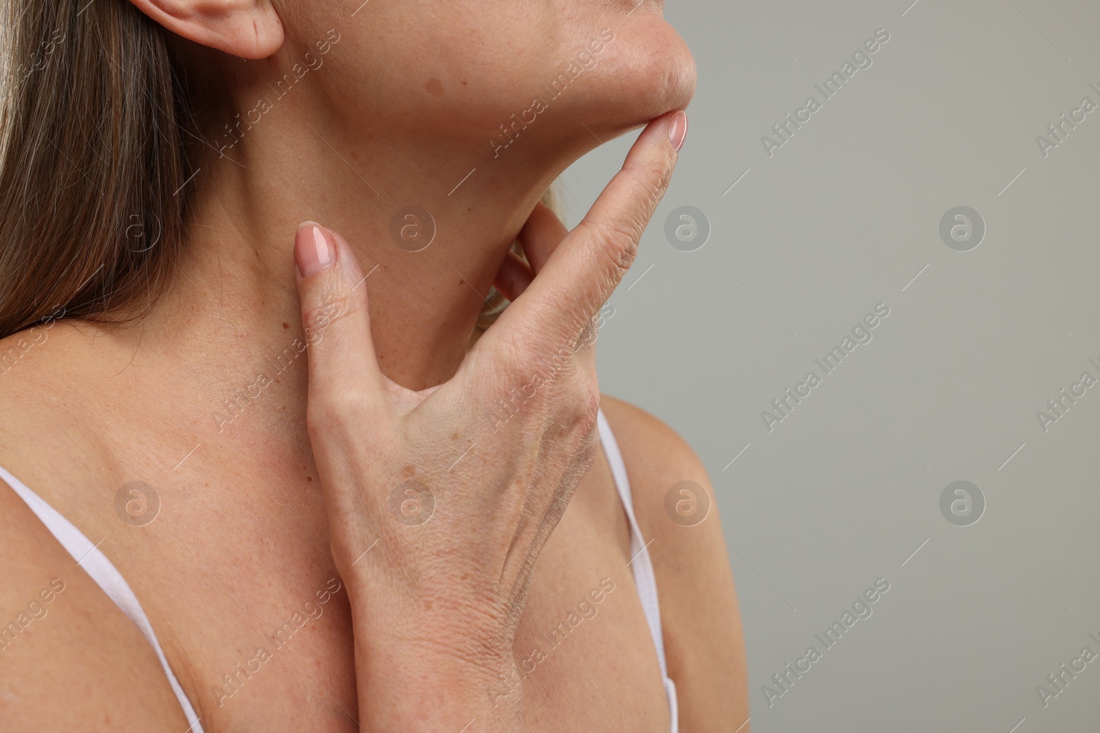 Photo of Mature woman with healthy skin on grey background, closeup. Space for text