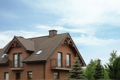 Photo of Beautiful house with brown roof against blue sky