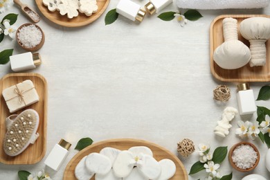 Photo of Jasmine flowers and set of spa essentials on white wooden table, flat lay. Space for text