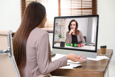 Image of Woman using video chat for online job interview in office