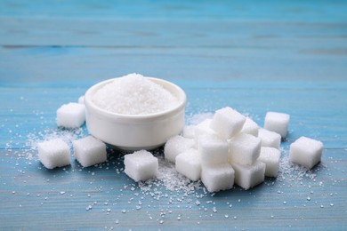 Photo of Different types of white sugar on light blue wooden table
