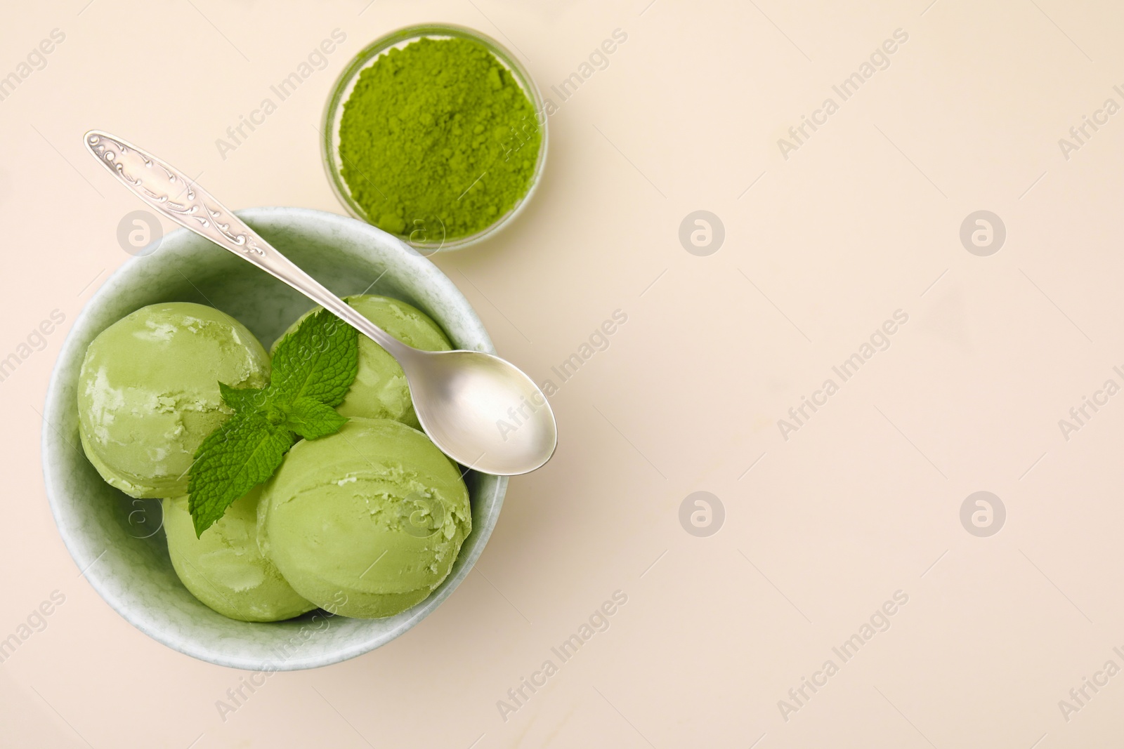 Photo of Tasty matcha ice cream, spoon and powder on beige table, flat lay. Space for text