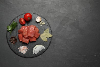 Photo of Raw beef meat and different ingredients for cooking delicious goulash on black table, top view. Space for text