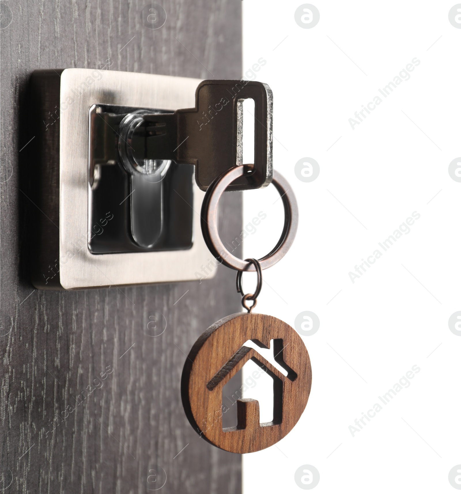 Photo of Mortgage and real estate. Open door with key and house shaped keychain on white background, space for text