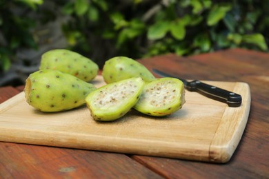 Tasty prickly pear fruits on wooden table outdoors