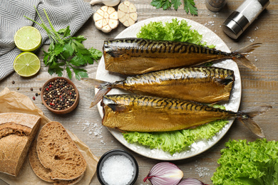 Flat lay composition with tasty smoked fish on wooden table