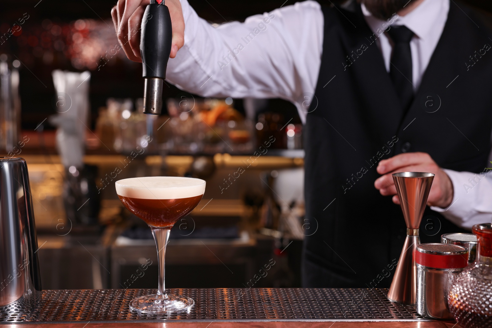 Photo of Bartender preparing Espresso Martini at bar counter, closeup. Alcohol cocktail