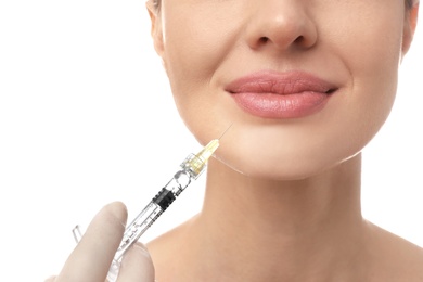 Photo of Beautiful woman getting facial injection on white background, closeup. Cosmetic surgery