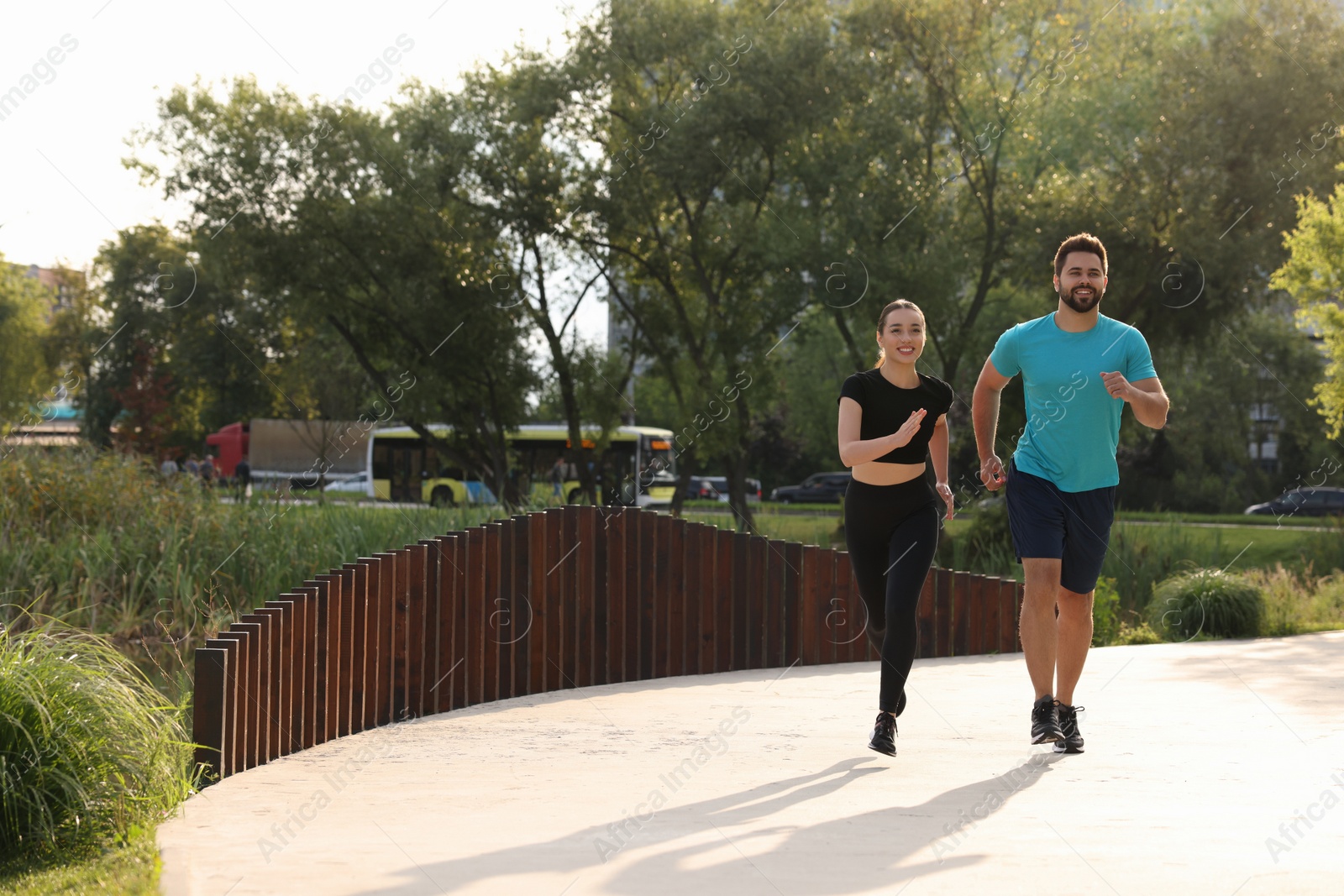 Photo of Healthy lifestyle. Happy couple running outdoors, space for text