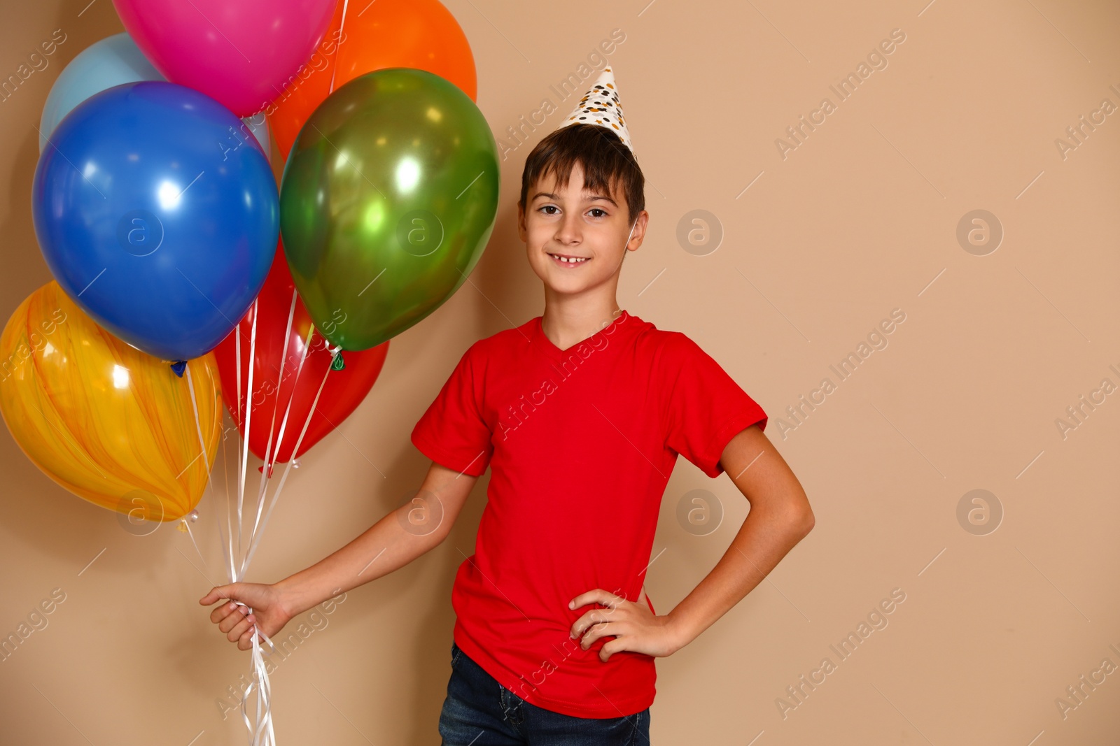 Photo of Happy boy with balloons on brown background. Birthday celebration