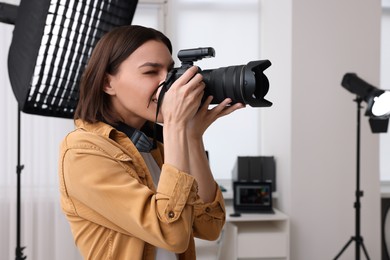 Photo of Professional photographer taking picture in modern photo studio